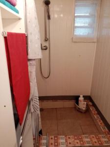 baño pequeño con ducha y suelo de baldosa. en Chalet d'une chambre avec terrasse et wifi a Les Makes, en Bellevue