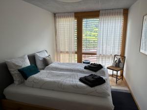 - une chambre avec 2 lits et une fenêtre dans l'établissement Apartment Casa Libelle by Interhome, à Sumvitg