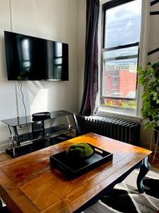 sala de estar con mesa de madera y TV en Walk everywhere! Stylish downtown Albany 2BR en Albany