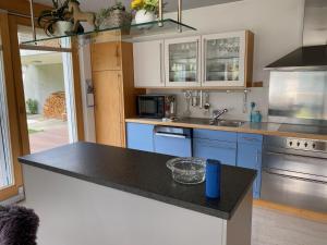 a kitchen with blue cabinets and a black counter top at Apartment Casa Libelle by Interhome in Sumvitg