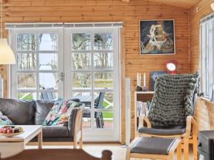 een woonkamer met een bank, stoelen en ramen bij Holiday Home Franka - all inclusive - 250m from the sea by Interhome in Klint