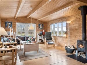 een woonkamer met houten wanden en een open haard bij Holiday Home Franka - all inclusive - 250m from the sea by Interhome in Klint