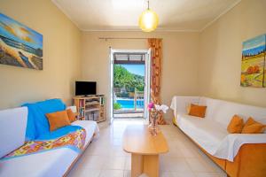 un soggiorno con due divani e un tavolo di Villa Marias Beach House by Villa Plus ad Ágios Stéfanos