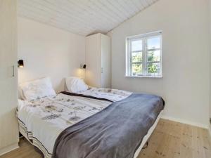een witte slaapkamer met een groot bed en een raam bij Holiday Home Baarde - all inclusive - 60m from the sea by Interhome in Grenå