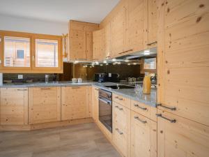 eine große Holzküche mit Holzschränken und Arbeitsflächen in der Unterkunft Apartment L' O 12 by Interhome in Ovronnaz