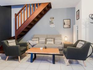 Una sala de estar con un sofá y dos sillas y una mesa. en Apartment Le Hameau du prieuré by Interhome, en Bonneville-sur-Touques