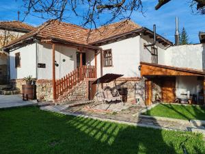 une maison blanche avec une terrasse couverte et une cour dans l'établissement Vila Antić, à Pirot