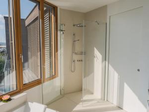 a glass shower in a bathroom with a window at Holiday Home Relax Lodge am See by Interhome in Neusiedl am See