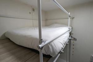 uma cama de hospital com lençóis brancos e um poste em Le Rochereau YourHostHelper em Grenoble