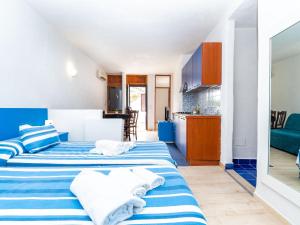 twee bedden in een kleine kamer met een keuken bij Apartment Freedom Relais Club-6 by Interhome in Massa Lubrense