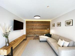 uma sala de estar com um sofá e uma televisão em Apartment Holzerjuwel by Interhome em Oberau
