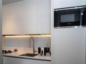 a white kitchen with a sink and a microwave at Apartment Mar di Roseto by Interhome in Roseto degli Abruzzi +26 photos