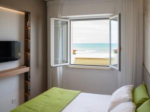 ロゼート・デッリ・アブルッツィにあるApartment Mar di Roseto by Interhomeのビーチの景色を望む窓付きのベッドルーム1室