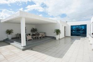 ein weißes Haus mit einer Terrasse mit Palmen darauf in der Unterkunft SUPER Spacious Modern Relax/CiPLA/CECiLIP in Santo Domingo