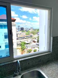 ein Fenster über einem Waschbecken mit Stadtblick in der Unterkunft SUPER Spacious Modern Relax/CiPLA/CECiLIP in Santo Domingo