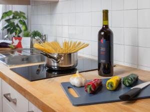 a bottle of wine and some vegetables on a cutting board at Studio Da Gina Honey Moon Ascona by Interhome in Ascona +12 photos