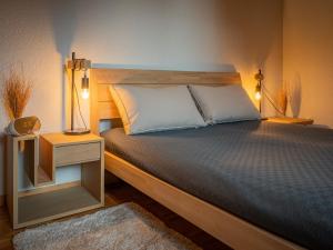 a bedroom with a bed with two lamps on it at Apartment Caroubier 6 by Interhome in Ovronnaz