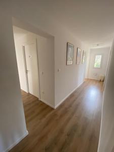 an empty living room with white walls and wood floors at U FARNIENTE in Patrimonio