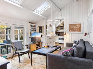 ein Wohnzimmer mit einem Sofa und einem Tisch in der Unterkunft Holiday Home Borghild - all inclusive - 1km from the sea by Interhome in Nykøbing Sjælland