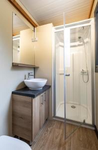 a bathroom with a sink and a shower at Huttopia Baie du Mont Saint Michel in Baguer-Pican