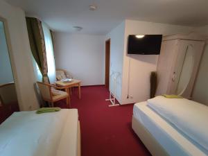 福爾巴克的住宿－Room in Guest room - Pension Forelle - Doppelzimmer，客房设有两张床、一张桌子和一台电视机。