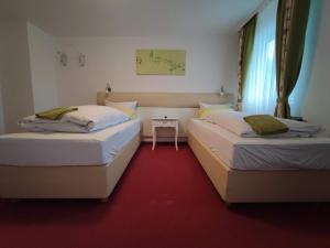 フォルバックにあるRoom in Guest room - Pension Forelle - Doppelzimmerの赤いカーペット敷きのドミトリールームのベッド2台