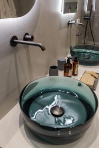 La salle de bains est pourvue d'un lavabo à bol vert sur un comptoir. dans l'établissement Palazzo Console, à Lecce