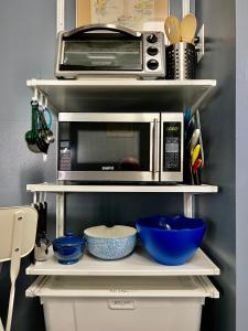 un forno a microonde su una mensola con ciotole e utensili di Cozy Penn King Studio w Kitchen and Free Street Parking! a Philadelphia