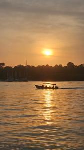 ein kleines Boot im Wasser bei Sonnenuntergang in der Unterkunft Hotel Blue Olas in Bocas del Toro