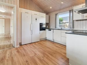 an empty kitchen with white appliances and wood floors at Holiday Home Blaga - all inclusive - 3-3km from the sea by Interhome in Rømø Kirkeby