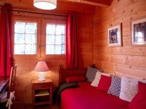 um quarto com uma cama com cortinas vermelhas e um candeeiro em Chalet Chalet Nirvana by Interhome em Chesières