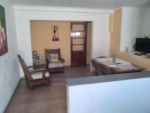 a living room with a table and chairs and a television at Queto in Santa Fe +4 photos