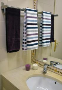 a bathroom with a sink and a mirror and towels at Exciting Beach Villa in Charneca