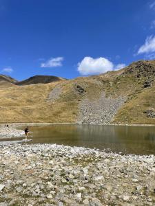 a person standing on the shore of a lake at Maison Gaia in Valdeblore