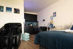 a bedroom with a bed and a kitchen at CuxHeaven modernes Studio-Apartment direkt am Meer mit Pool, Sauna und Massage in Cuxhaven