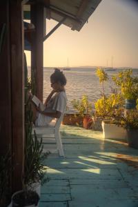 Eine Frau, die auf einer Veranda sitzt und ein Buch liest. in der Unterkunft Hotel Blue Olas in Bocas del Toro