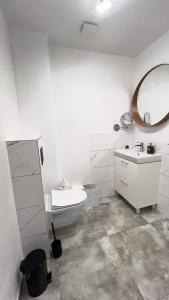 Baño blanco con lavabo y espejo en Domek 80m2, en Tczew
