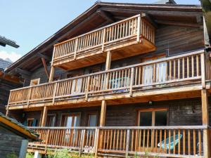 a wooden house with balconies on the side of it at Apartment Les Moulins by Interhome in Verbier