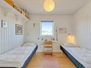 two beds in a room with a window at Holiday Home Carstina - all inclusive - 400m from the sea by Interhome in Skagen