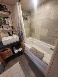 een badkamer met een wastafel, een bad en een wastafel bij Cliffside Hideaways 