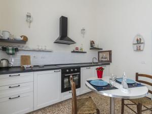 a white kitchen with a table and a stove at Apartment Casa Adele by Interhome in Imperia