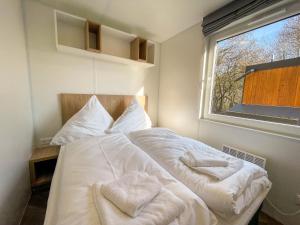 a bedroom with a bed with towels on it at Holiday Home Tiny Haus Auszeit by Interhome in Riedenburg