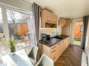 a kitchen with wooden cabinets and a large window at Holiday Home Tiny Haus Auszeit by Interhome in Riedenburg