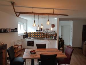 une cuisine avec une table en bois et des chaises ainsi qu'une salle à manger dans l'établissement Apartment Haus Bettina Fischer by Interhome, à Churwalden