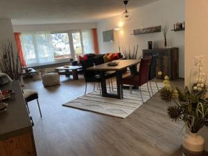 Il comprend une cuisine et un salon avec une table et des chaises. dans l'établissement Apartment Haus Bettina Fischer by Interhome, à Churwalden