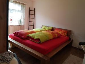 - un lit avec des oreillers colorés dans une chambre dans l'établissement Apartment Haus Bettina Fischer by Interhome, à Churwalden