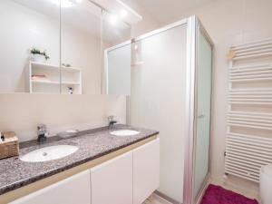 y baño con 2 lavabos y ducha. en Apartment De tulp by Interhome, en De Haan