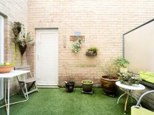 un patio con macetas y una pared de ladrillo en Apartment De tulp by Interhome, en De Haan