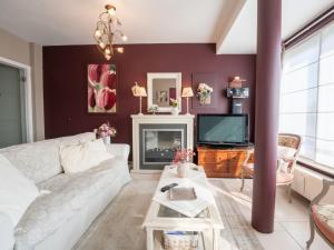 sala de estar con sofá blanco y TV en Apartment De tulp by Interhome, en De Haan