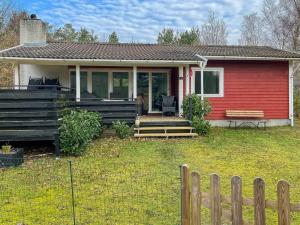 una casa rossa e bianca con una recinzione in legno di Holiday Home Betti - all inclusive - 700m from the sea by Interhome a Vester Sømarken